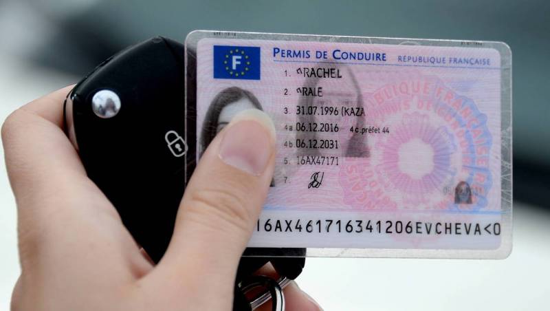 Main tenant un permis de conduire et des clés de voiture