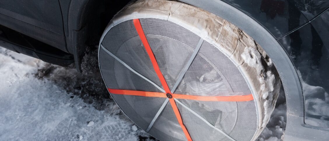 Des chaussettes neiges montées sur un véhicule qui circule sur une route enneigée