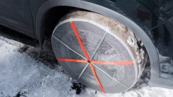 Des chaussettes neiges montées sur un véhicule qui circule sur une route enneigée